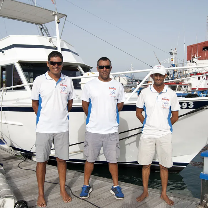 I tre membri dell'equipaggio dello Yate Sofía sul pontile davanti alla barca a Los Cristianos